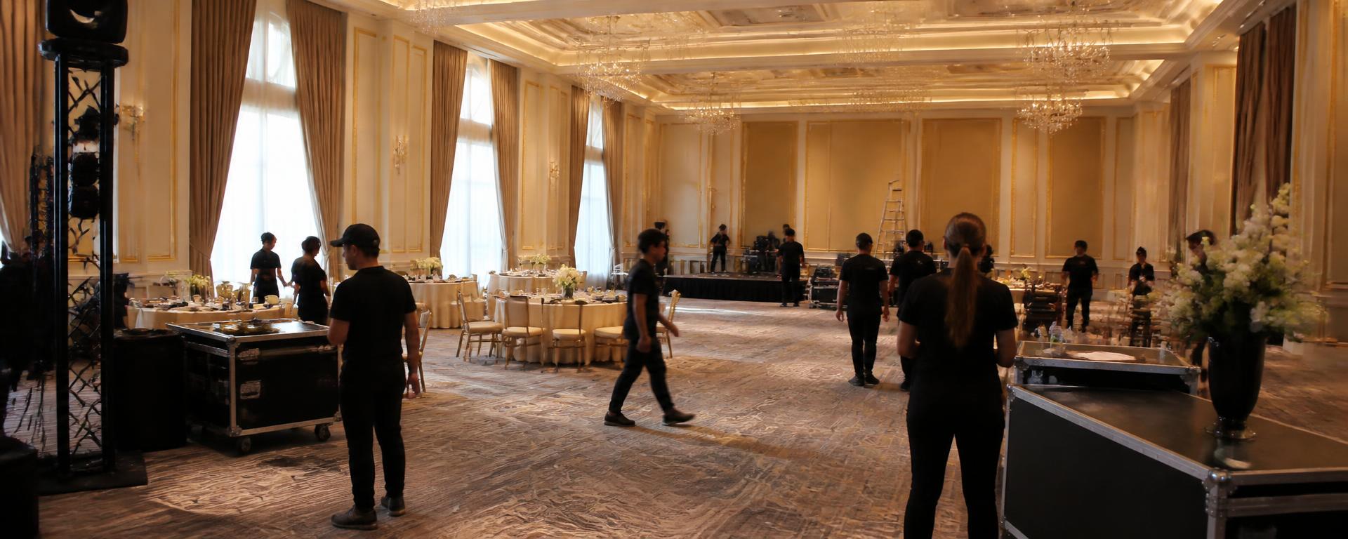 Equipo de staff coordinando el montaje de un salón de eventos antes de la llegada de invitados
